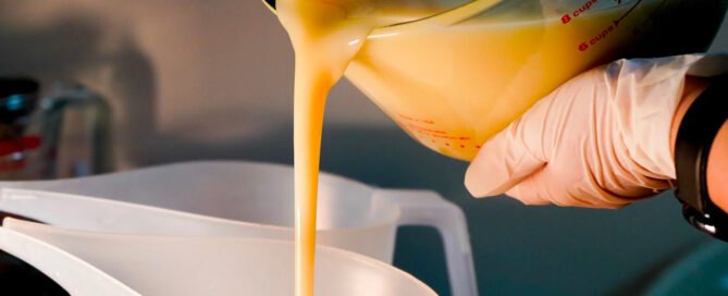 Latex gloves pouring juice into measuring jar