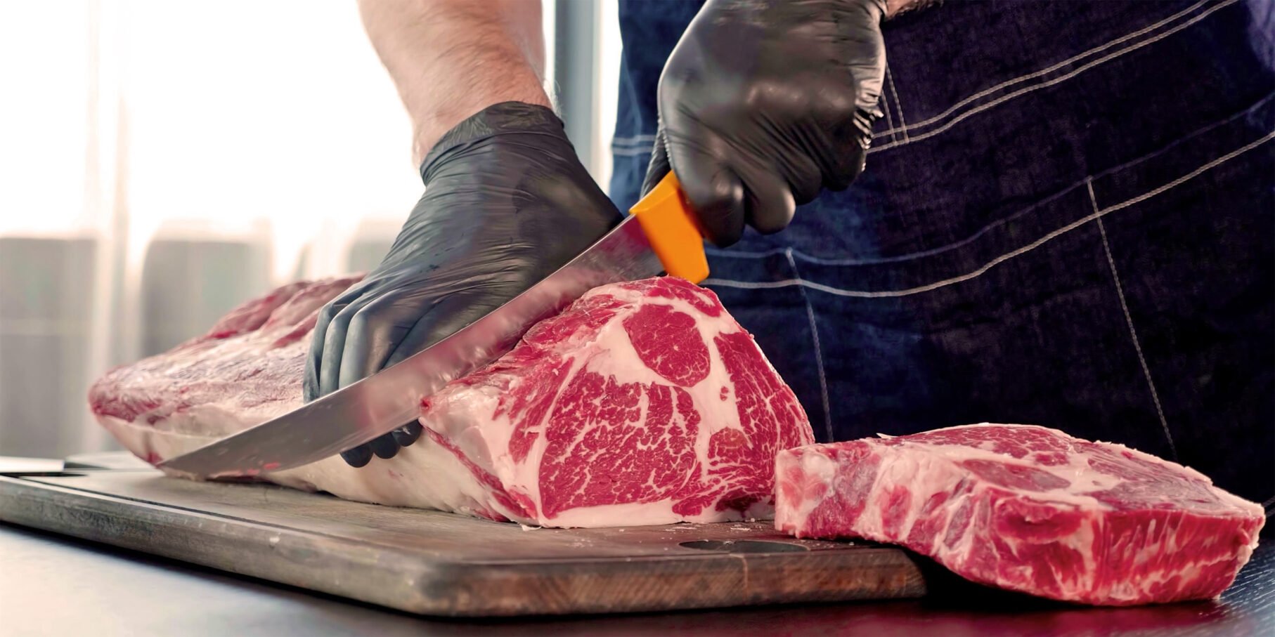 Food safe black prosenso gloves cutting ribeye steak